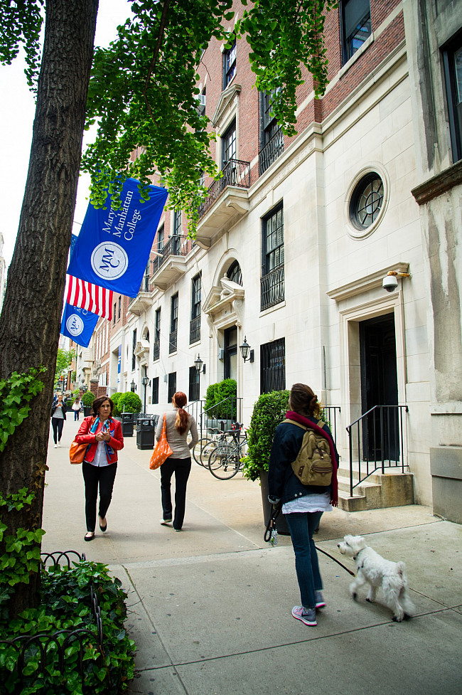 Woman walking her dog and people walking in different directions outside of Marymount Manhattan College 71st Street Building